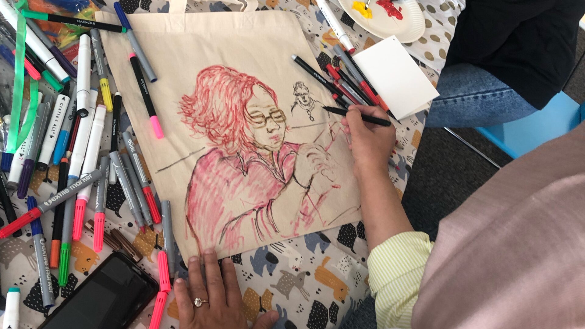 Woman drawing a portrait of another woman.